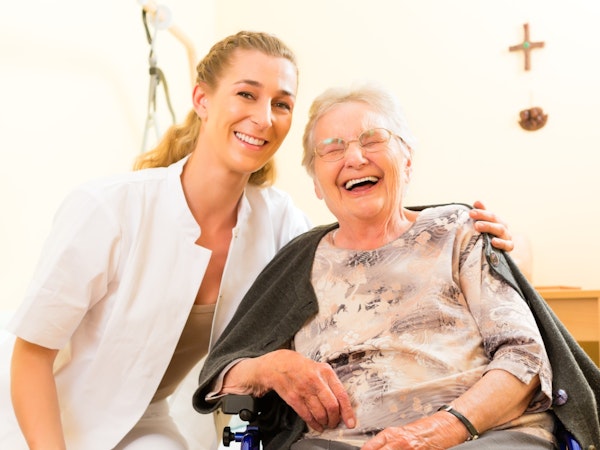 An older person receiving help from a carer at home