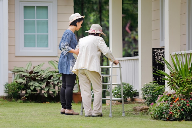 Assisting elderly lady with walking frame