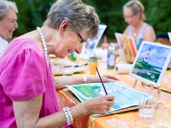 Group of residents painting at their aged care home