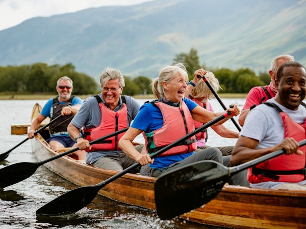 Older group of people paddling a boat